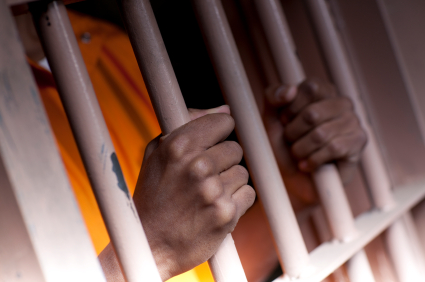 Man Behind Bars in Orange Jumpsuit