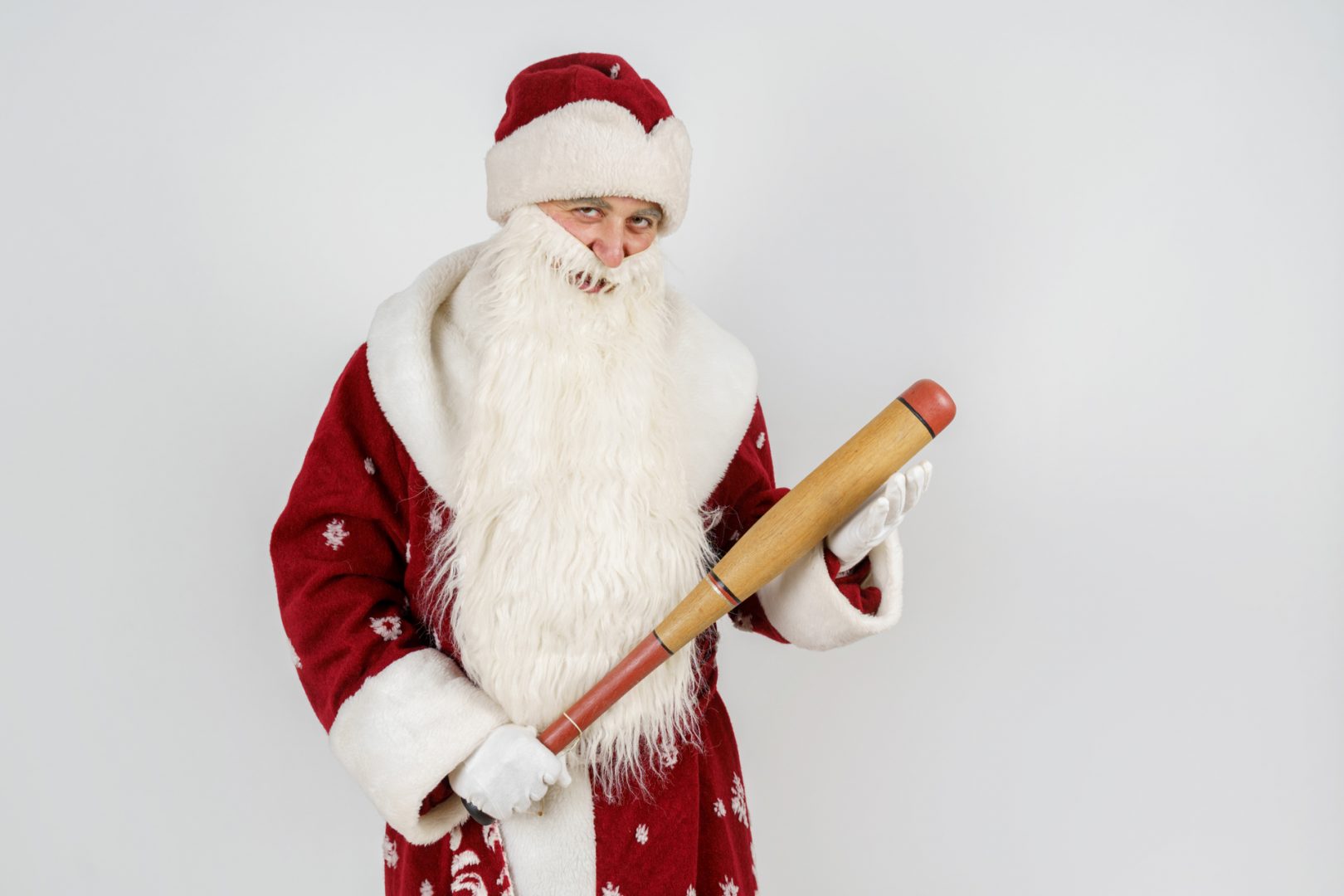 Santa Claus with a baseball bat in his hands.